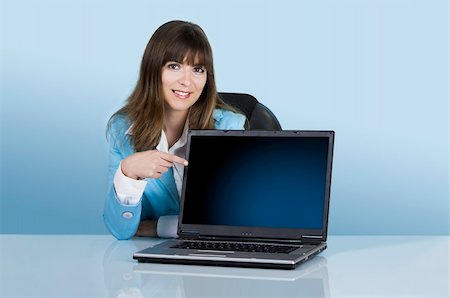 simsearch:400-08554629,k - Satisfied businesswoman showing a presentation with a laptop on a blue background (This file include a path on the laptop screen) Fotografie stock - Microstock e Abbonamento, Codice: 400-04453171