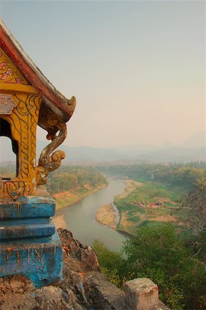 Located in the center of Luang Prabang, Laos.  Wat Phou Si sits at the top of the hill overlooking the city and farmland below. Stock Photo - Budget Royalty-Free & Subscription, Code: 400-04453619