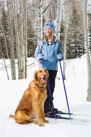 ski outerwear - Mid adult smiling Caucasian female skier wearing blue ski clothing standing on ski slope with Golden Retriever. Stock Photo - Budget Royalty-Free & Subscription, Code: 400-04465300