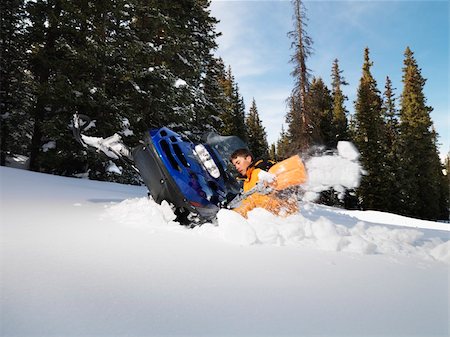 simsearch:400-03944669,k - Young man digging out snowmobile submerged in the snow. Photographie de stock - Aubaine LD & Abonnement, Code: 400-04465318