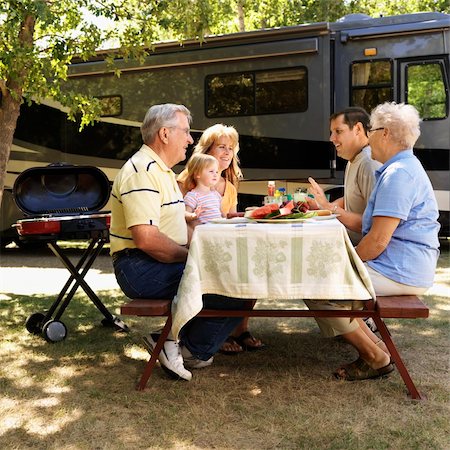 Three generation Caucasian family seated at picnic table in front of recreational vehicle talking. Stock Photo - Budget Royalty-Free & Subscription, Code: 400-04465347