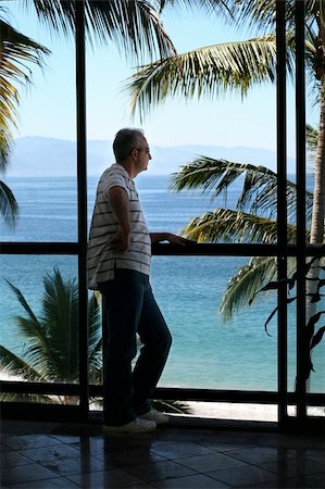 simsearch:622-06370189,k - Man standing by the window in a tropical resort Stock Photo - Budget Royalty-Free & Subscription, Code: 400-04465838