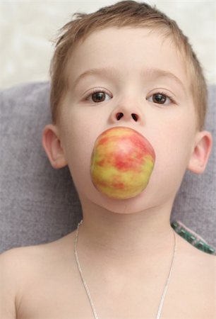 The boy which holds an apple a mouth Stockbilder - Microstock & Abonnement, Bildnummer: 400-04467078