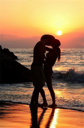 simsearch:400-03942507,k - Couple kissing on the beach at sunset Fotografie stock - Microstock e Abbonamento, Codice: 400-04467162