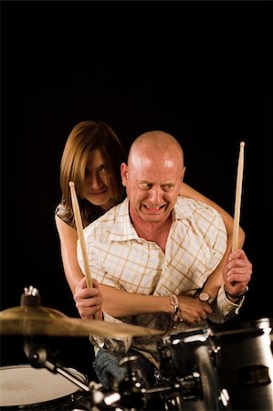 shot of woman bugging drummer playing over black backdrop Stock Photo - Budget Royalty-Free & Subscription, Code: 400-04467667