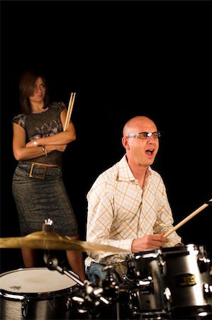 simsearch:400-06133570,k - drummer playing over black backdrop with woman standing in background Stock Photo - Budget Royalty-Free & Subscription, Code: 400-04467669