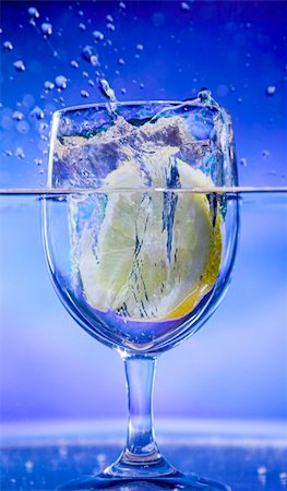 simsearch:6113-06626095,k - lemon splash in transparent glass over blue background Stock Photo - Budget Royalty-Free & Subscription, Code: 400-04468424