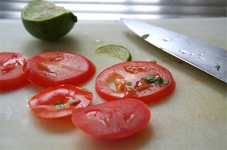 simsearch:400-04347888,k - Sliced tomatoes and limes used in asian cuisine with knife on chopping board Stockbilder - Microstock & Abonnement, Bildnummer: 400-04468444