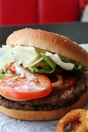 simsearch:628-02954492,k - Fastfood hamburger bun on paper wrapper Photographie de stock - Aubaine LD & Abonnement, Code: 400-04468497
