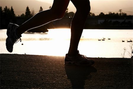 feet marathon - Woman jogging along a river at sunset Stock Photo - Budget Royalty-Free & Subscription, Code: 400-04468920