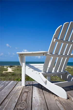 simsearch:400-03923118,k - Empty white adirondack chair on wooden deck facing beach. Fotografie stock - Microstock e Abbonamento, Codice: 400-04469034