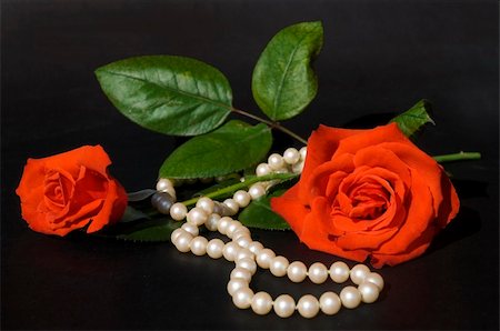 Necklace of mallorca pearls and roses on a black background in warm natural light. Narrow dof on roses. Stockbilder - Microstock & Abonnement, Bildnummer: 400-04469874
