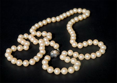 Necklace of mallorca pearls and roses on a black background in warm natural light. Narrow dof on roses. Stockbilder - Microstock & Abonnement, Bildnummer: 400-04469872