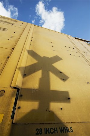 Shadow of a railroad crossing sign cast against the yellow side of a freight train car. Stock Photo - Budget Royalty-Free & Subscription, Code: 400-04460316