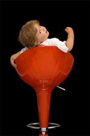 diverse families - Little girl playing and having fun posing on a red swivel chair - isolated on black Foto de stock - Super Valor sin royalties y Suscripción, Código: 400-04461121