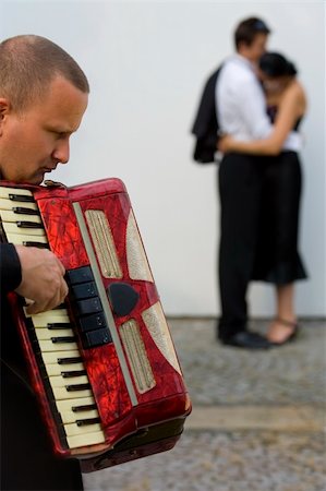 A street musician playing his accordian serenades two young lovers Photographie de stock - Aubaine LD & Abonnement, Code: 400-04461376