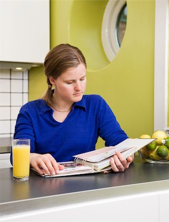 A young woman in the kitchen looking at recipes. Stock Photo - Budget Royalty-Free & Subscription, Code: 400-04462111