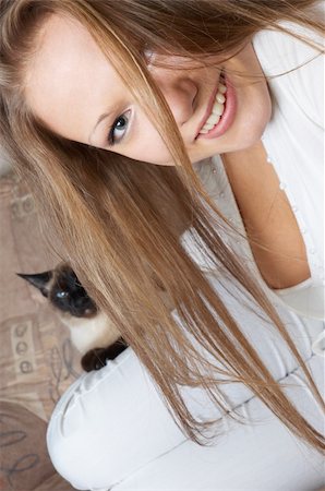 young smiling girl in white with cat sitting on her leg Foto de stock - Super Valor sin royalties y Suscripción, Código: 400-04474704