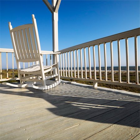 simsearch:400-03923118,k - Rocking chair on porch with railing overlooking beach at Bald Head Island, North Carolina. Fotografie stock - Microstock e Abbonamento, Codice: 400-04475169