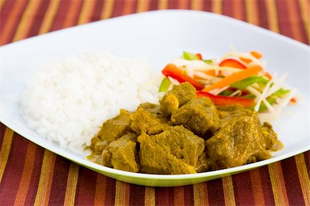 simsearch:400-04440947,k - Caribbean style curried goat served with steamed rice. Dish accompanied with vegetable salad. Shallow DOF. Fotografie stock - Microstock e Abbonamento, Codice: 400-04475213