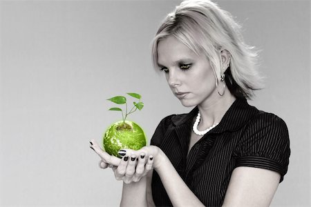 Woman holding the earth with plant over a neutral background. Foto de stock - Royalty-Free Super Valor e Assinatura, Número: 400-04475322