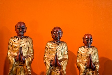 simsearch:400-03944899,k - Three wooden statues of Buddhist disciples against orange wall. Stock Photo - Budget Royalty-Free & Subscription, Code: 400-04475788