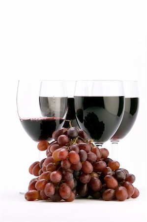 simsearch:400-04935153,k - Multiple glasses of red wine being poured with grapes against a plain background. Photographie de stock - Aubaine LD & Abonnement, Code: 400-04475905