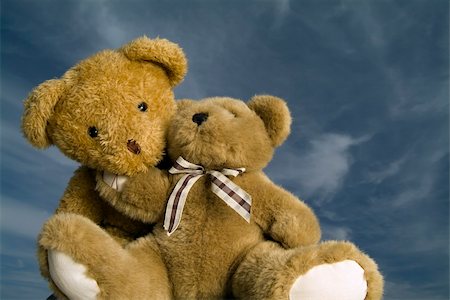 two teddy bears hugging each other agaist blue sky with cirrus clouds Stock Photo - Budget Royalty-Free & Subscription, Code: 400-04475928