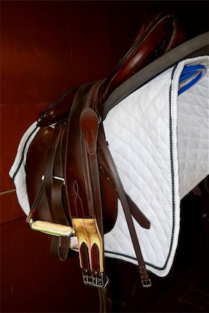 steigbügel - Saddle on a rack in a tack room, horseback riding equipment Stockbilder - Microstock & Abonnement, Bildnummer: 400-04476474