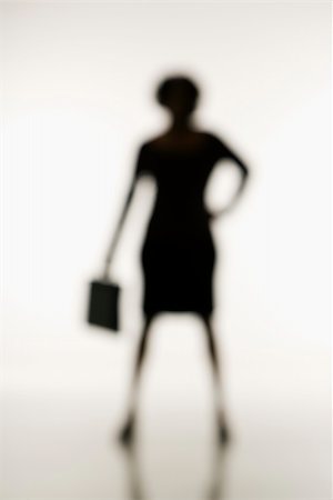 Soft focus silhouette of businesswoman standing with hand on hip holding briefcase. Stock Photo - Budget Royalty-Free & Subscription, Code: 400-04477826