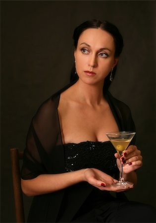 simsearch:400-04479015,k - The beautiful woman with a glass of martini on a dark background Stock Photo - Budget Royalty-Free & Subscription, Code: 400-04479015