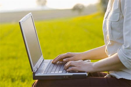 simsearch:400-08997106,k - Woman typing on a laptop outside in a meadow. Focus only on the right hand. Stock Photo - Budget Royalty-Free & Subscription, Code: 400-04479400
