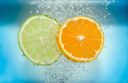 simsearch:400-03931888,k - Lemon and tangarine slices in water with air bubbles on blue background. Stock Photo - Budget Royalty-Free & Subscription, Code: 400-04479499