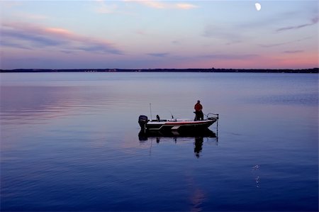 A man fishing in the early morning or early evening from his boat. Stock Photo - Budget Royalty-Free & Subscription, Code: 400-04479855