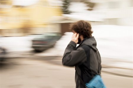 A motion blur abstract of a person walking in a hurry talking on a cell phone Stock Photo - Budget Royalty-Free & Subscription, Code: 400-04470049