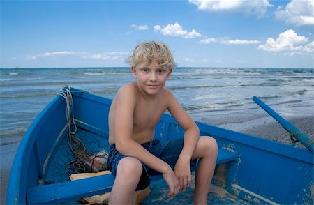 family relaxing with kids in the sun - Boy on a blue boat Photographie de stock - Aubaine LD & Abonnement, Code: 400-04470577