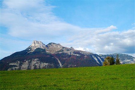 simsearch:400-07210714,k - a mountain surrounded with green fields and blue cloudy sky Fotografie stock - Microstock e Abbonamento, Codice: 400-04470747