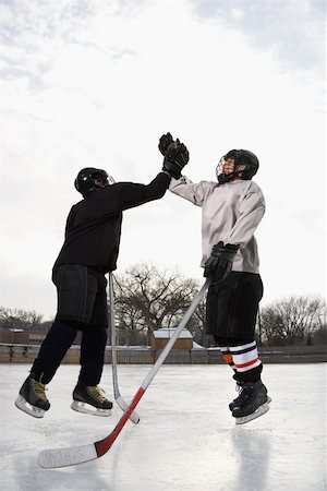 Two boys in ice hockey uniforms giving eachother high five on ice rink. Stock Photo - Budget Royalty-Free & Subscription, Code: 400-04471039
