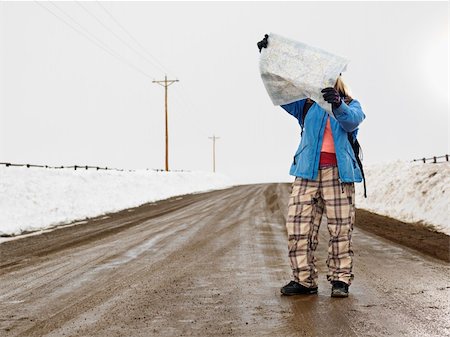 Young woman in winter clothes standing on muddy dirt road looking at map. Stock Photo - Budget Royalty-Free & Subscription, Code: 400-04471052