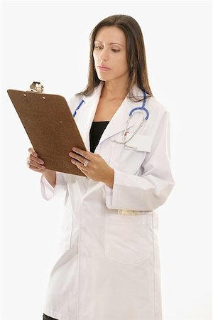 simsearch:400-04508758,k - Attractive female doctor holding a medical clipboard and reading. Foto de stock - Super Valor sin royalties y Suscripción, Código: 400-04472179