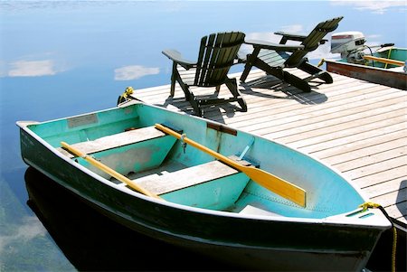 simsearch:862-06542036,k - Paddle boat and two adirondack wooden chairs on dock facing a blue lake Photographie de stock - Aubaine LD & Abonnement, Code: 400-04473968