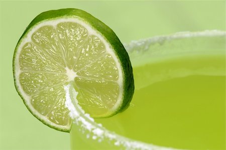 salt rim - A macro, closeup shot of a juicy lime on the edge of a margarita glass, against a green background. Stock Photo - Budget Royalty-Free & Subscription, Code: 400-04485057