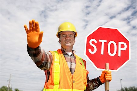 A construction worker stopping traffic, holding a stop sign. Stock Photo - Budget Royalty-Free & Subscription, Code: 400-04485165