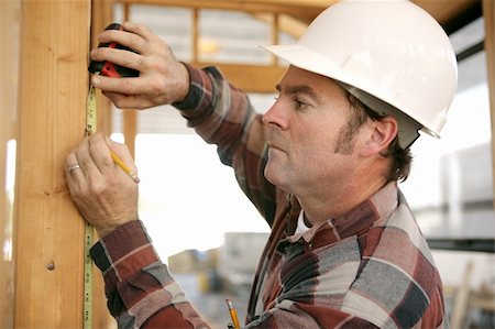A construction working taking measurments and marking a wood beam on a house frame. Stock Photo - Budget Royalty-Free & Subscription, Code: 400-04485166