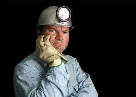 A coal miner in a dark mineshaft, looking unhappy and disgruntled. Foto de stock - Super Valor sin royalties y Suscripción, Código: 400-04485175