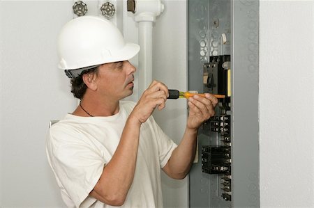 simsearch:400-04485314,k - An electrician installing a breaker in an electric panel.  Model is an actual electrician and all work is being performed according to industry codes and safety practices. Fotografie stock - Microstock e Abbonamento, Codice: 400-04485313