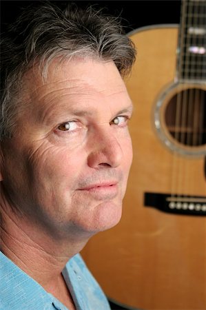 simsearch:400-03972426,k - A handsome musician posing with his guitar in the background. Photographie de stock - Aubaine LD & Abonnement, Code: 400-04486285