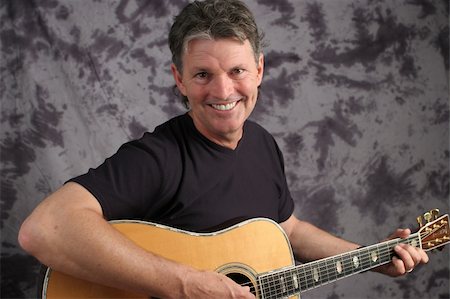 simsearch:400-03972483,k - A handsome, middle aged guitarist with a big, toothy smile. Photographie de stock - Aubaine LD & Abonnement, Code: 400-04486297