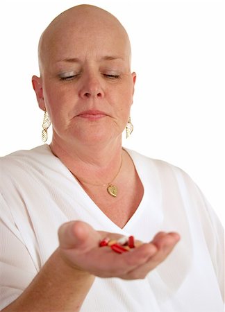 A medical patient looking at a handful of pills, reluctant to take them. Photographie de stock - Aubaine LD & Abonnement, Code: 400-04486309