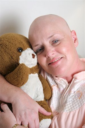 A cancer survivor hugging a teddy bear and smiling. Stock Photo - Budget Royalty-Free & Subscription, Code: 400-04486311
